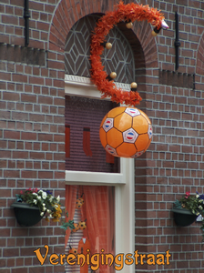 716539 Fotopaneeltje, met een afbeelding van een met oranje artikelen versierd venster in de Verenigingstraat te ...